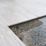 Flooring of a pool side space by Iran Cream Travertine - Marbleopolis